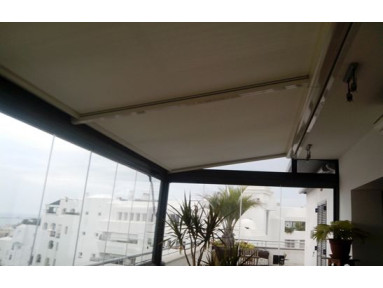Store véranda avec système de guidage par cordes toile micro-perforée Soltis